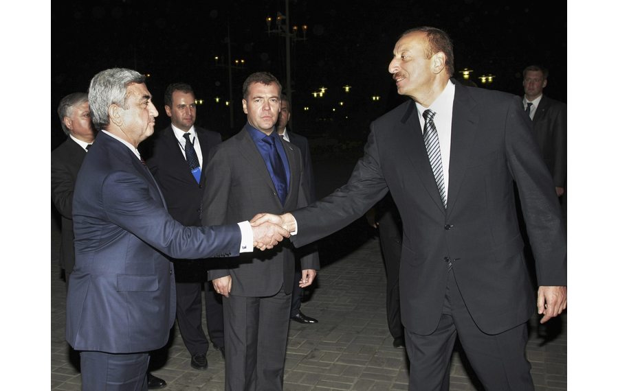 Armenia's President Sargsyan shakes hands with Azerbaijan's President Aliyev as Russia's President Medvedev looks on in Astrakhan